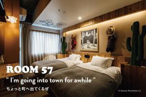 神户ピーナッツホテル/PEANUTS HOTEL的一间带两张床的卧室和仙人掌