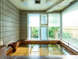 唐津飞鸟酒店 的一间空房间,设有大窗户和浴缸
