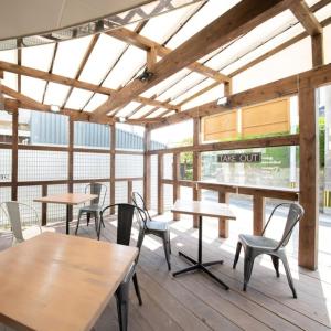 唐津飞鸟酒店 的一间设有木桌、椅子和窗户的自助餐厅