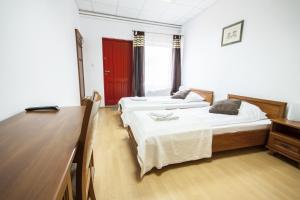 切拉季特克里马蒂酒店的配有书桌和书桌的客房内的两张床