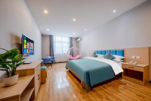 昆明曼朵酒店(昆明长水国际机场店)的一间卧室配有一张床、一张书桌和一台电视。