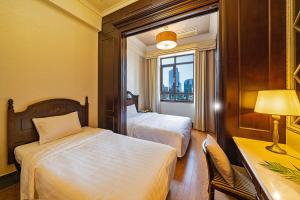 首尔Yeoksam Artnouveau City Hotel and Residence的酒店客房设有两张床、一张书桌和一个窗户。