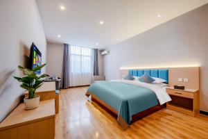 昆明曼朵酒店(昆明长水国际机场店)的一间卧室配有一张大床和电视
