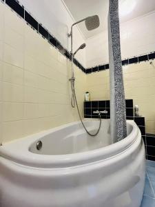 维尔纽斯Beepartment的浴室设有带淋浴的白色浴缸。