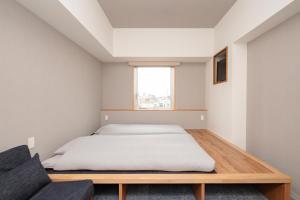 东京OTHER SPACE Asakusa的一间卧室配有一张床和一张沙发
