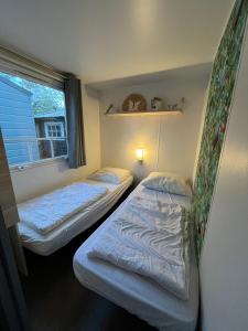 哈登贝赫Chalet vakantiepark Kleine Belties 18的小型客房 - 带2张床和窗户