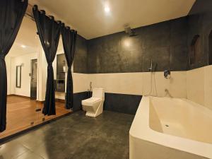 巴加Hotel Vaggi's Place的带浴缸、卫生间和盥洗盆的浴室