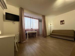 切法卢Cefalù Suite的一间卧室配有一张床、一张书桌和一个窗户。