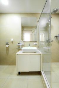 阿斯塔纳HIGHVIL APARTAMENTS的白色的浴室设有水槽和淋浴。