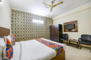 新德里FabExpress Smart Stay的一间卧室配有一张床、一张书桌和一台电视。