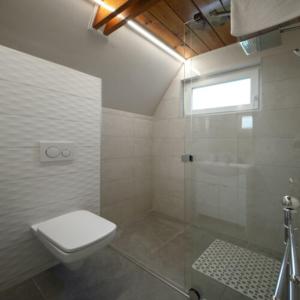欧尔菲Horizont idéző ParkMotel的白色的浴室设有卫生间和淋浴。