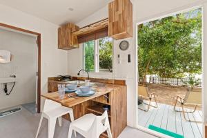 苏梅岛Brand New Beachfront & Secluded Tiny House的厨房配有木制柜台和桌椅