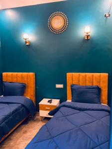 突尼斯Hotel Dar Ali的一间卧室设有两张床和蓝色的墙壁