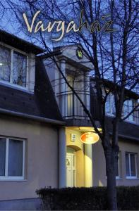 布达厄尔什Varga-ház panzió的前面有一棵树的房子