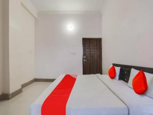 坎普尔OYO Flagship Radhe Radhe Hotels的一间卧室配有一张带红色枕头的大床