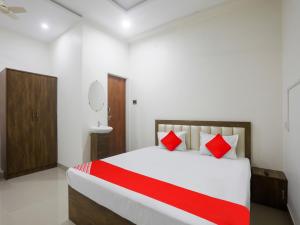 那格浦尔OYO Flagship Hotel Rahul Service Appartment 2的卧室配有带红色枕头的大型白色床