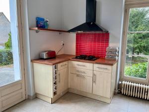 奥登河畔的布雷特维尔Superbe Maison de maître 10 chambres 300 m2 Caen的一间带炉灶和红色瓷砖的小厨房