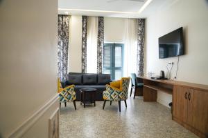 PithorāgarhHOTEL GRP INN CITY HOME的客厅配有沙发、椅子和书桌