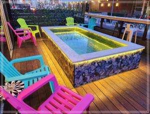 特拉维夫Dream Beach Hotel And Spa的游泳池位于甲板上,配有五颜六色的椅子