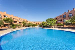 格拉纳迪利亚德亚沃纳Home2Book La Tejita Beach的一个大型蓝色游泳池,其建筑背景为: