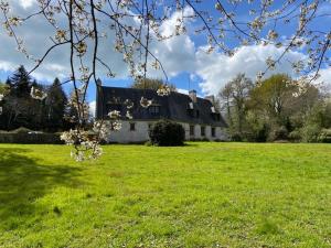 Clohars-FouesnantMaison familiale pour des vacances nature en bord de mer à Bénodet的绿色田野中的一座古宅