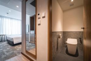 曼谷Sotetsu Grand Fresa Bangkok 相鉄グランドフレッサバンコク的一间带卫生间的浴室和一张位于客房内的床。