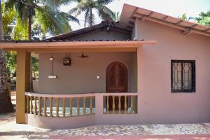 波戈马洛Valerys Nest Bogmalo - Private villa near the beach and Dabolim airport的一个小房子,设有门廊和阳台