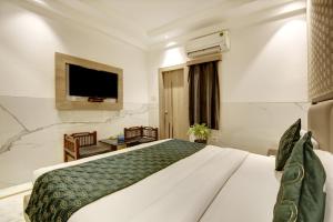 新德里Hotel International Inn by Star group - Near Delhi Airport的一间酒店客房,配有一张床和一台电视