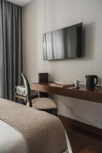 圣马力诺Welcome Hotel的酒店客房设有一张桌子和一台墙上的电视
