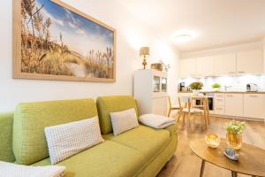 宾茨Fewo Auszeit im Haus Strandburg的一间带绿色沙发的客厅和一间厨房
