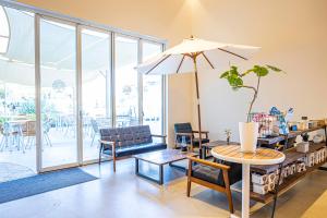 菰野町glampark FREE AND EASY CAMP RESORT　三重県的客厅配有桌椅和遮阳伞