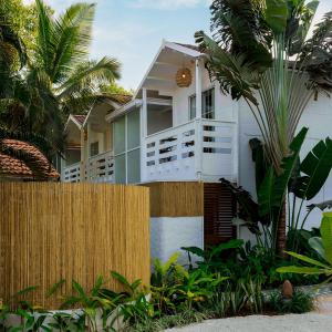 莫尔吉姆Azora by Ayatana, Goa的棕榈树围栏后面的房子