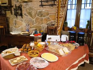 塞普尔韦达Hotel Rural El Cañón del Duratón的桌上有面包和其他食物