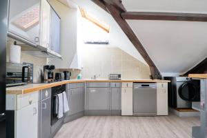 南特LE NID DE LA GLORIETTE Hyper centre NANTES的厨房配有白色橱柜和拱形天花板