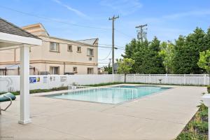 威尔伍德克拉斯特408 E Myrtle Rd, Unit 105的一个带白色围栏的庭院内的游泳池