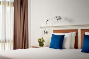 辛特拉NH Sintra Centro的配有蓝色枕头的床的酒店客房
