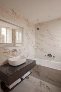 罗马维米纳勒酒店的一间带水槽、浴缸和镜子的浴室
