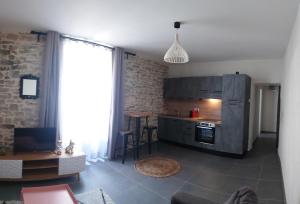 尼姆Logement cosy的客厅设有带桌子和台面的厨房