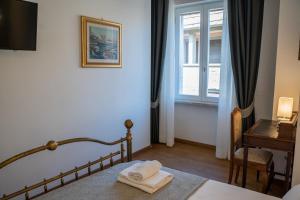 佛罗伦萨Residenza degli Speziali的一间卧室配有一张床、一张书桌和一个窗户。