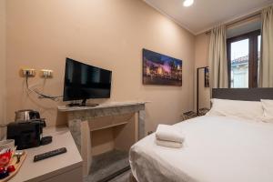 都灵Torino Station Relais的一间卧室配有一张床和一台平面电视