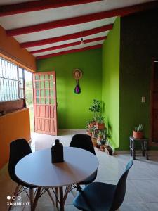 拉基拉Buenavista, espacio natural的配有桌椅和绿色墙壁的客房
