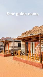 瓦迪拉姆Star Guide Camp的沙漠中带桌椅的房子