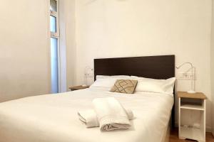 加瓦Panoramic view Gavà Mar的卧室配有白色的床和2条毛巾