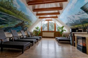 利托斯基简斯特拉尚夫卡让斯卡考利巴酒店的一间带椅子和画作壁炉的房间