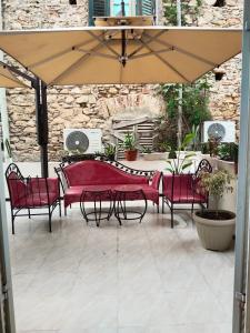 突尼斯Hotel Marhaba - Beb Bhar Tunis的露台的遮阳伞下的桌椅