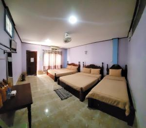 万荣Vang Vieng Chanthala Hotel 1的一间设有两张床和一张桌子的房间