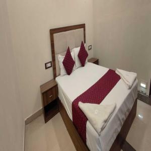 孟买Hotel Blue Sky Residency的一间卧室配有一张带红色和白色枕头的大床