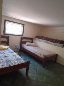 乌巴图巴Casa praia da enseada em Ubatuba的客房设有两张床和窗户。