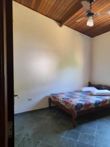 乌巴图巴Casa praia da enseada em Ubatuba的一间带一张床铺的卧室,位于带天花板的房间内