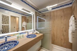 格拉纳达萨雷酒店的一间带两个盥洗盆和大镜子的浴室